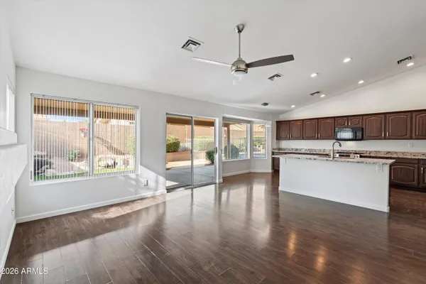 a view of a kitchen with kitchen island a stove a sink a refrigerator and wooden floor