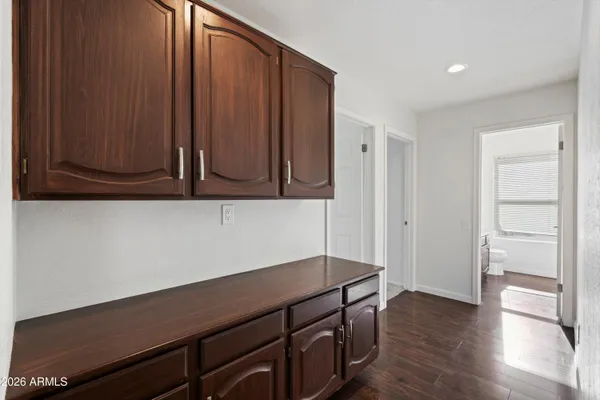 an empty room with wooden floor and cabinet