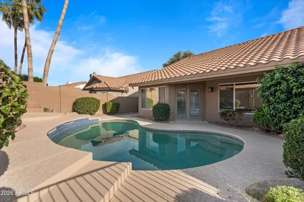 a view of a house with pool and chairs