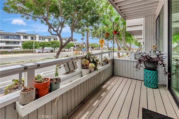 a view of a balcony with wooden floor and outdoor seating