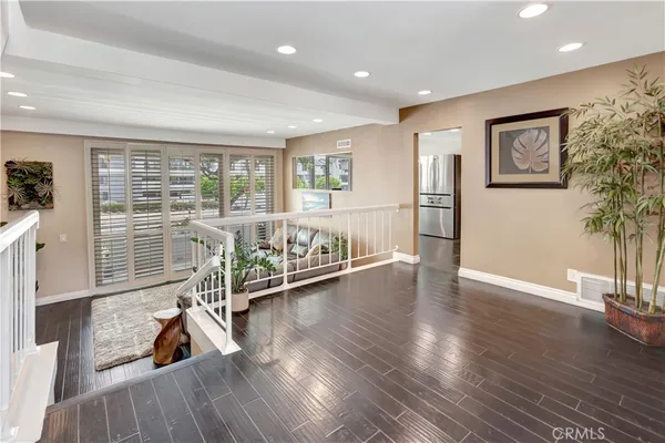 a view of a work space with wooden floor and windows
