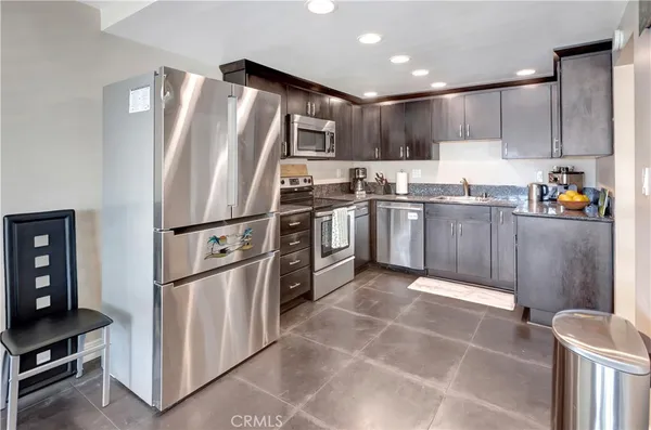 a kitchen with stainless steel appliances granite countertop a refrigerator stove a sink and a microwave