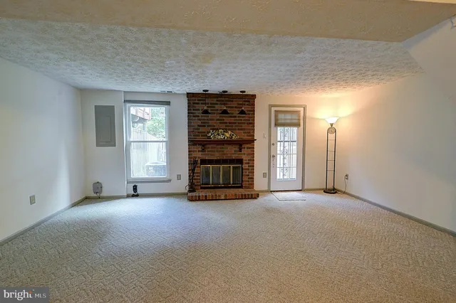 an empty room with a fireplace and cabinet