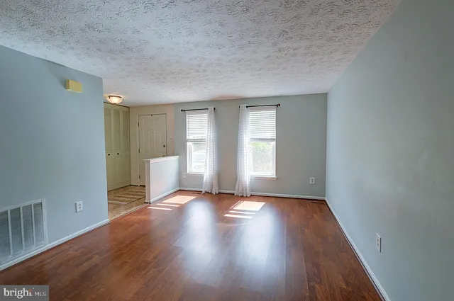 a view of a livingroom with wooden floor and window