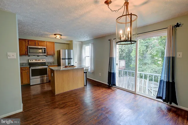 a view of a kitchen with a sink wooden floor and a counter top space