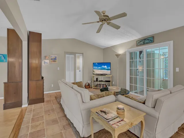 a living room with furniture a large window and a ceiling fan