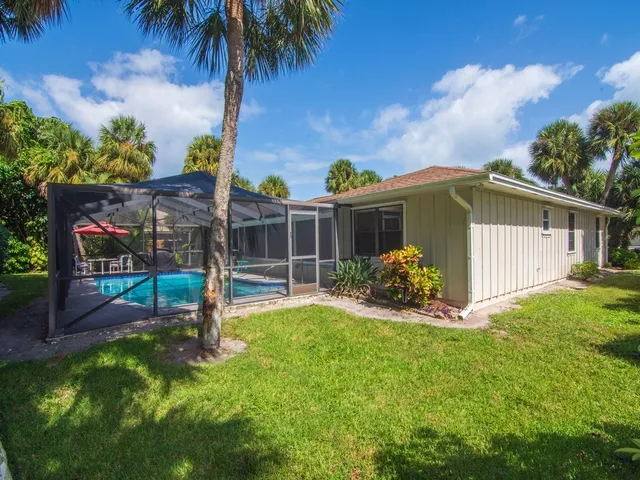 a view of a house with backyard and sitting area