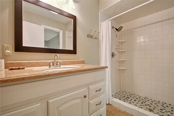 a bathroom with a sink vanity granite and a mirror