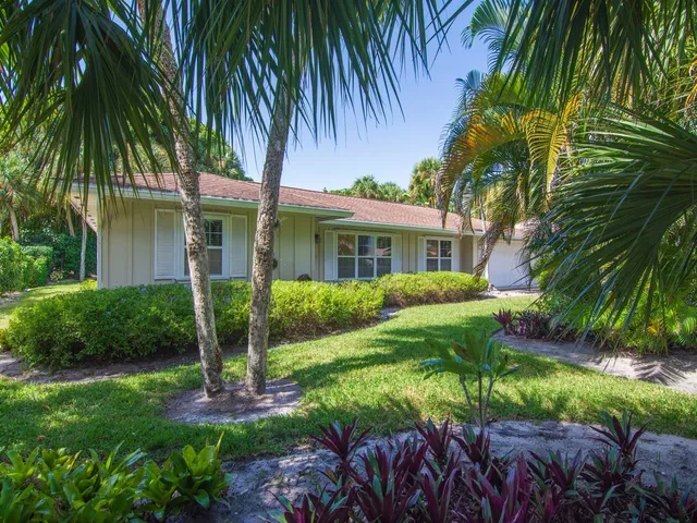 a view of a house with a yard and potted plants