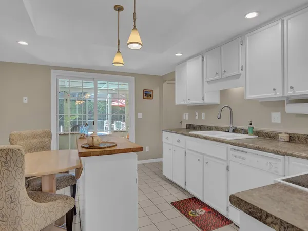 a kitchen that has a sink and chairs in it