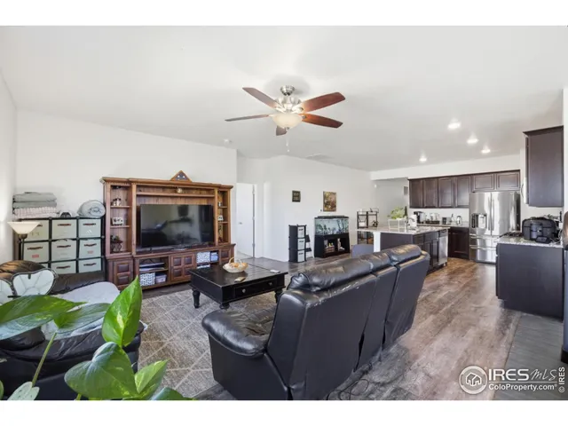 a living room with furniture kitchen view and a flat screen tv