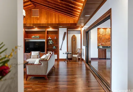 a living room with furniture floor to ceiling window and wooden floor
