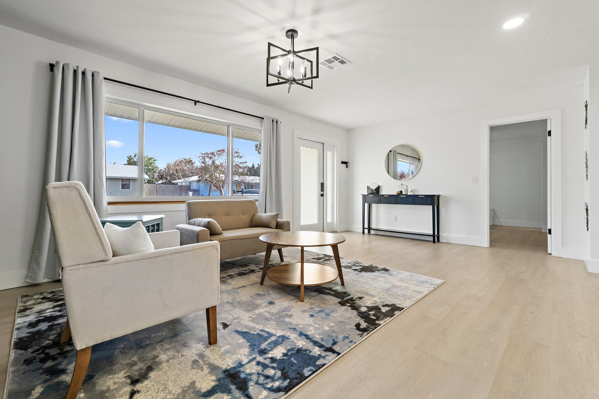 1851 Southeast Jackson Street Stuart, FL 34997 - Photo 12 of 61 a living room with furniture a rug and a large window