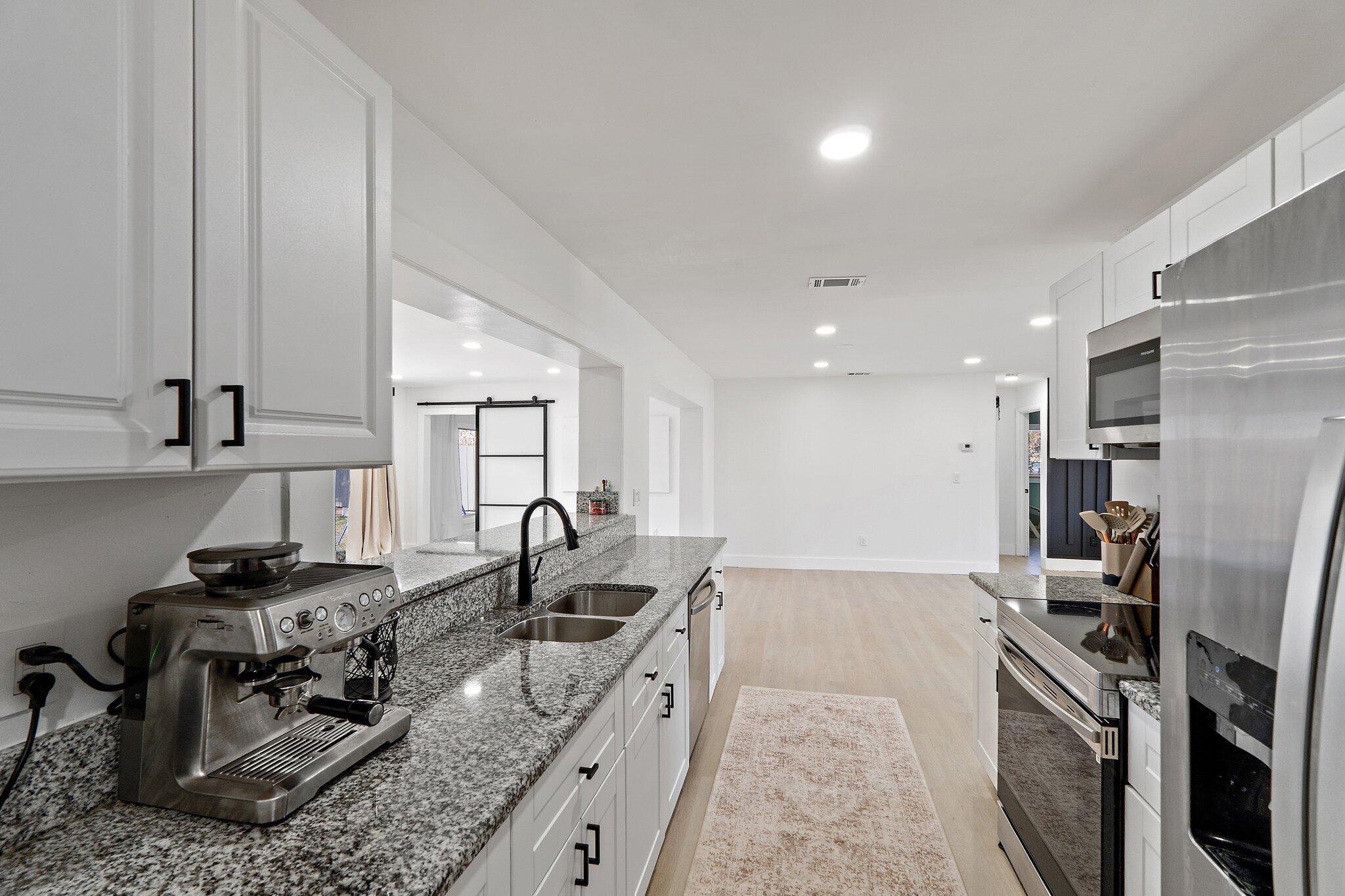 1851 Southeast Jackson Street Stuart, FL 34997 - Photo 17 of 61 a kitchen with stainless steel appliances granite countertop a sink stove and refrigerator