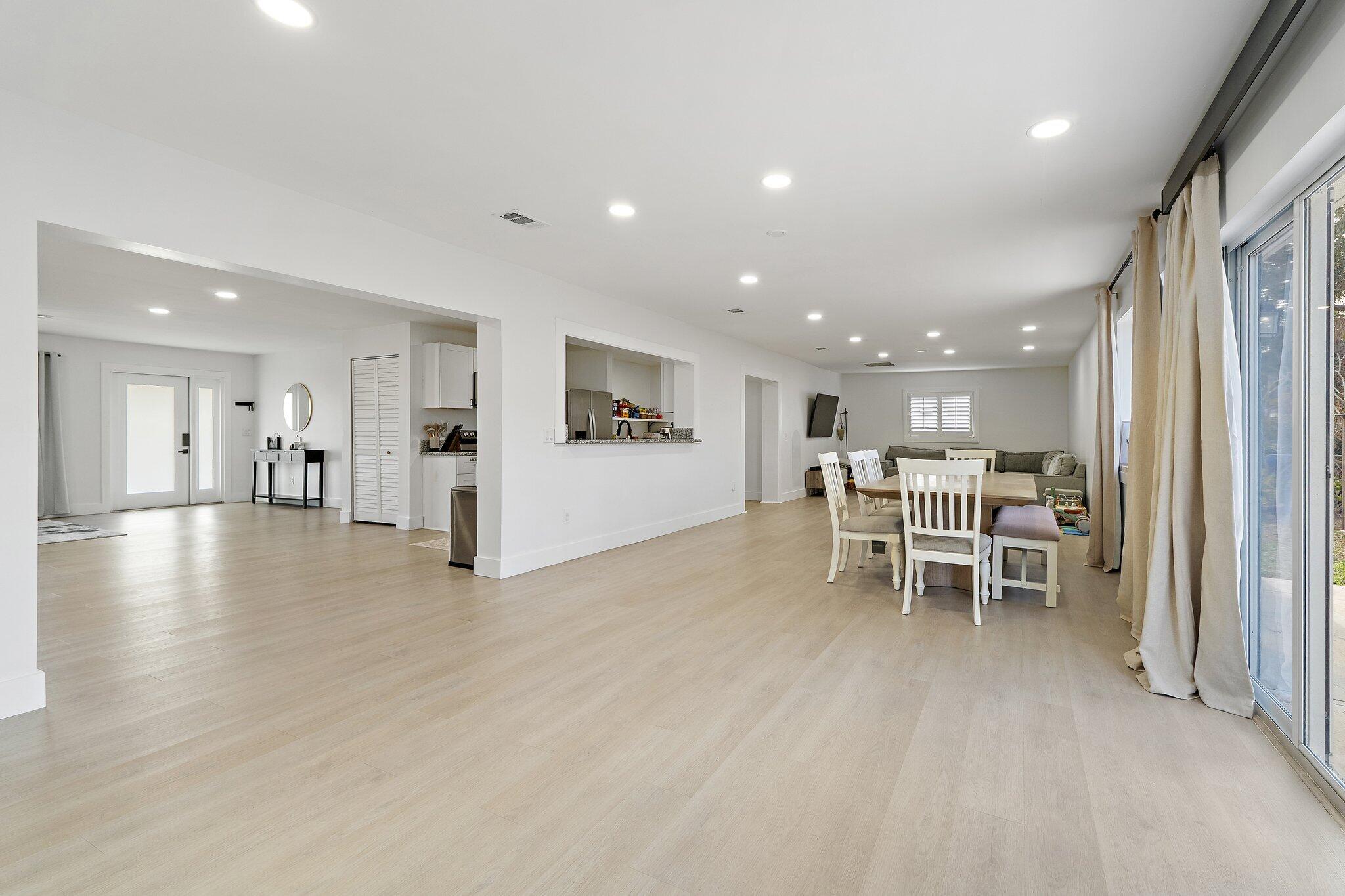 1851 Southeast Jackson Street Stuart, FL 34997 - Photo 21 of 61 a view of a kitchen with a dining table chairs wooden floor and a kitchen