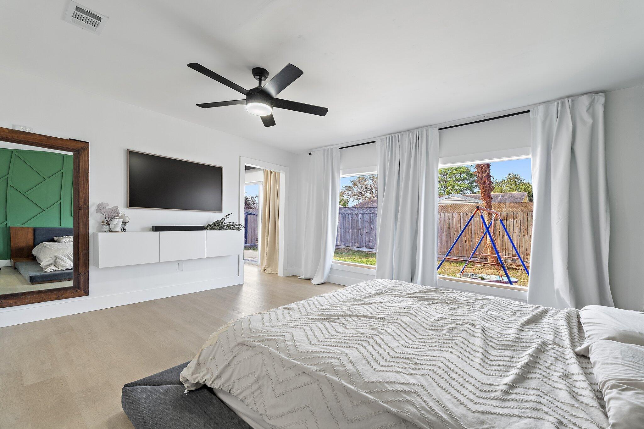 1851 Southeast Jackson Street Stuart, FL 34997 - Photo 29 of 61 a bedroom with a bed and a flat screen tv