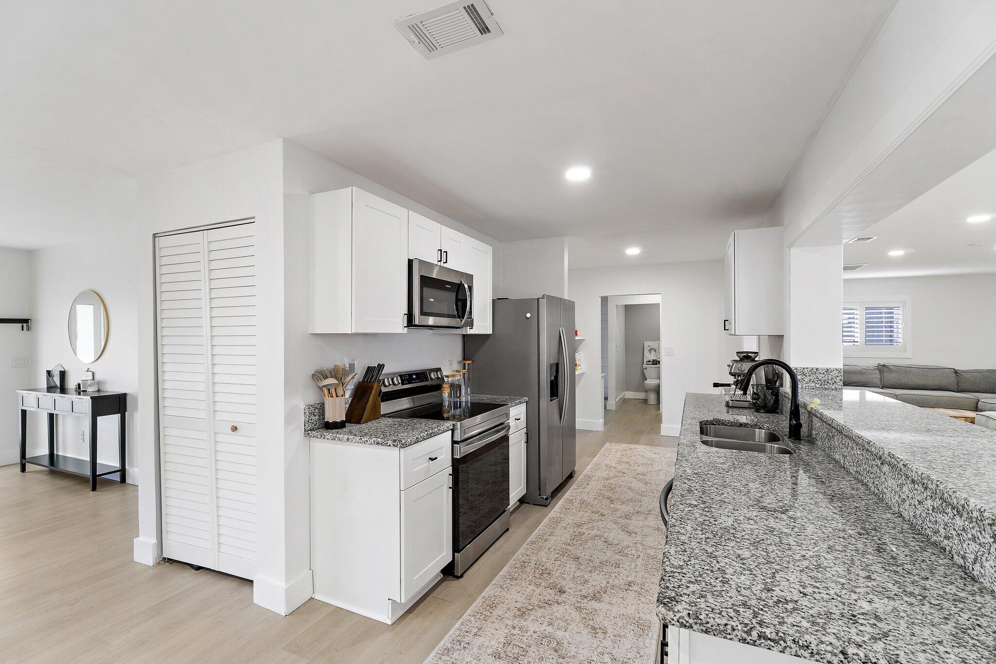 1851 Southeast Jackson Street Stuart, FL 34997 - Photo 3 of 61 a large white kitchen with stainless steel appliances lots of counter top space