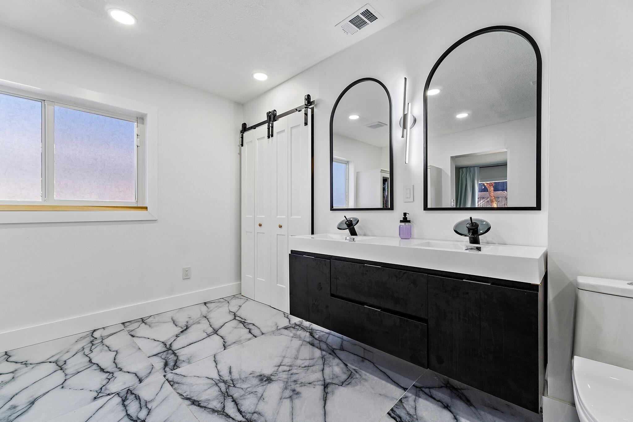 1851 Southeast Jackson Street Stuart, FL 34997 - Photo 34 of 61 a spacious bathroom with a sink and a mirror