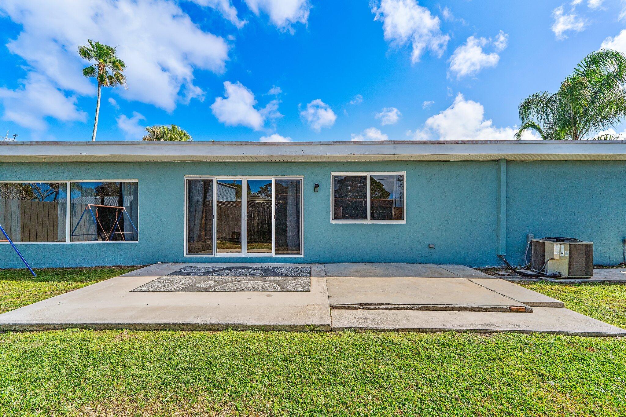 1851 Southeast Jackson Street Stuart, FL 34997 - Photo 52 of 61 a front view of a house with a yard and potted plants
