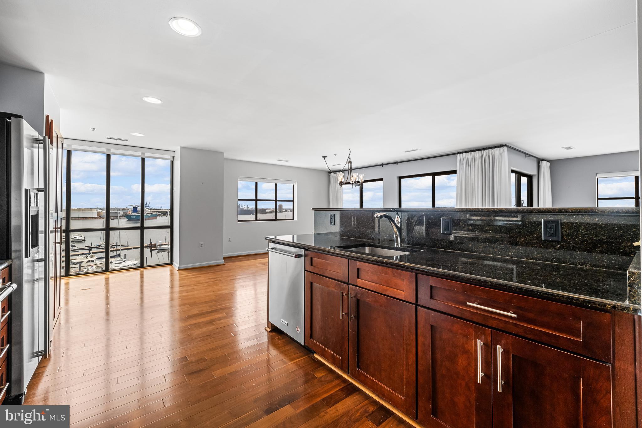 2702 Lighthouse Point East, Unit 638 Baltimore, MD 21224 - Photo 14 of 72 a large kitchen with stainless steel appliances granite countertop a lot of counter space and wooden floor