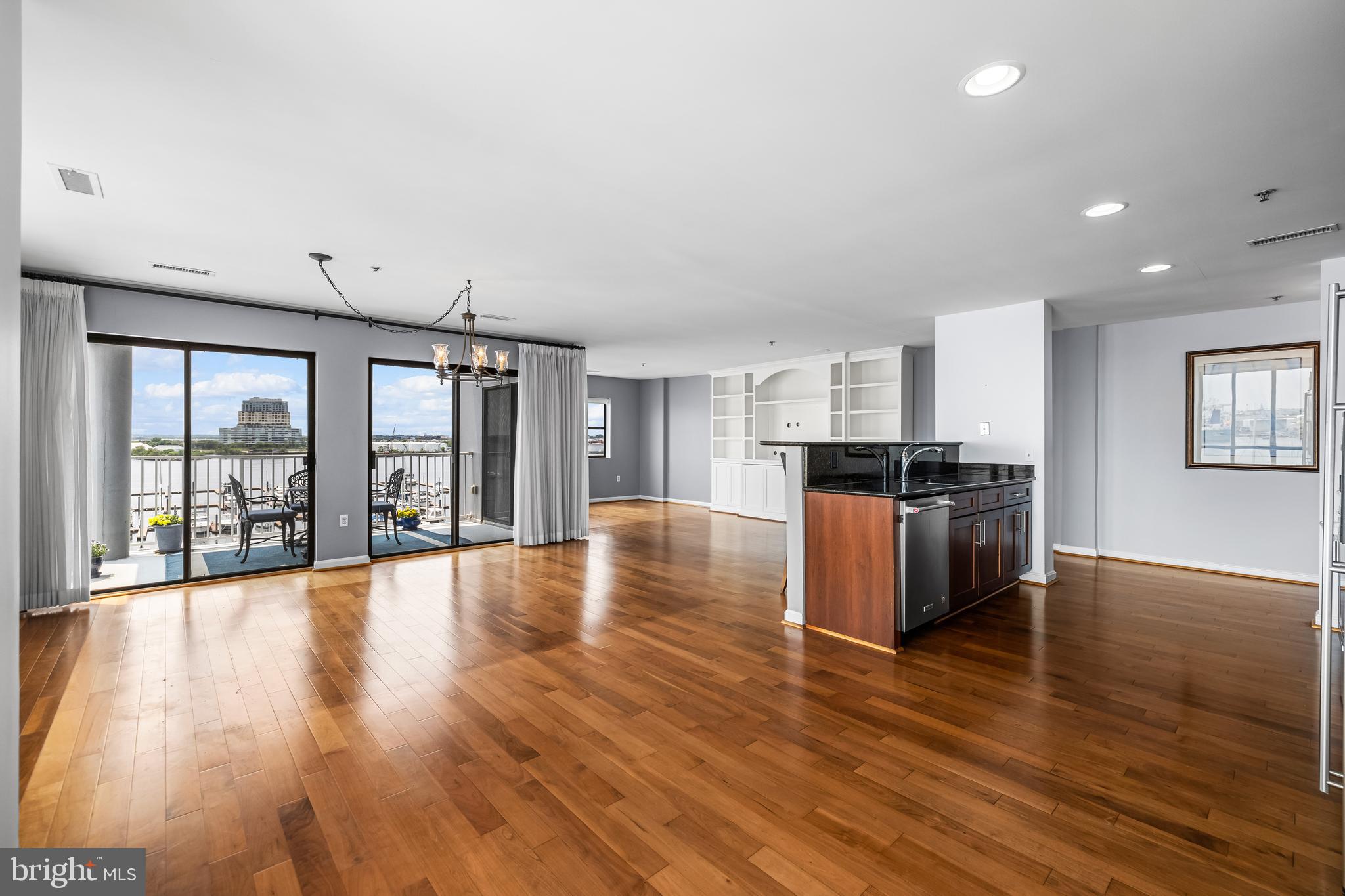 2702 Lighthouse Point East, Unit 638 Baltimore, MD 21224 - Photo 16 of 72 a view of an empty room and kitchen with hardwood floor