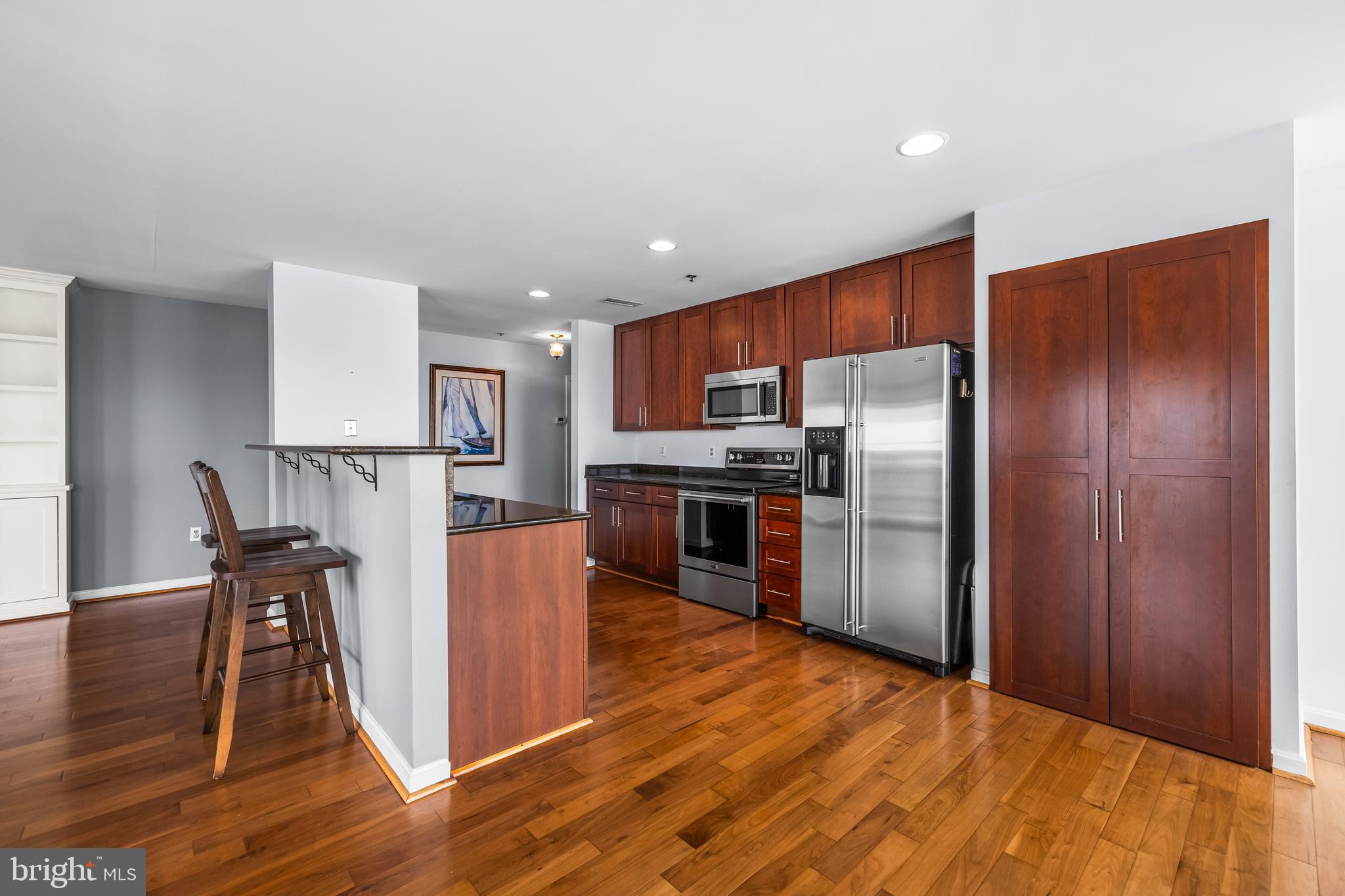 2702 Lighthouse Point East, Unit 638 Baltimore, MD 21224 - Photo 17 of 72 a kitchen with stainless steel appliances granite countertop a refrigerator microwave and wooden floor