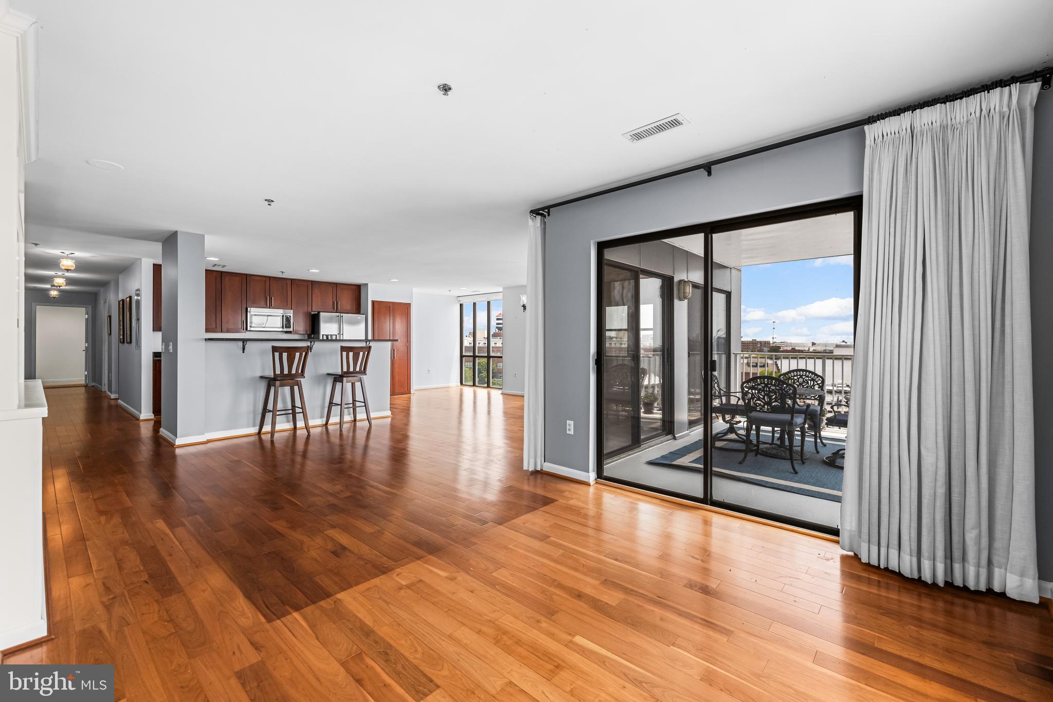 2702 Lighthouse Point East, Unit 638 Baltimore, MD 21224 - Photo 22 of 72 a view of a living room with floor to ceiling window and wooden floor