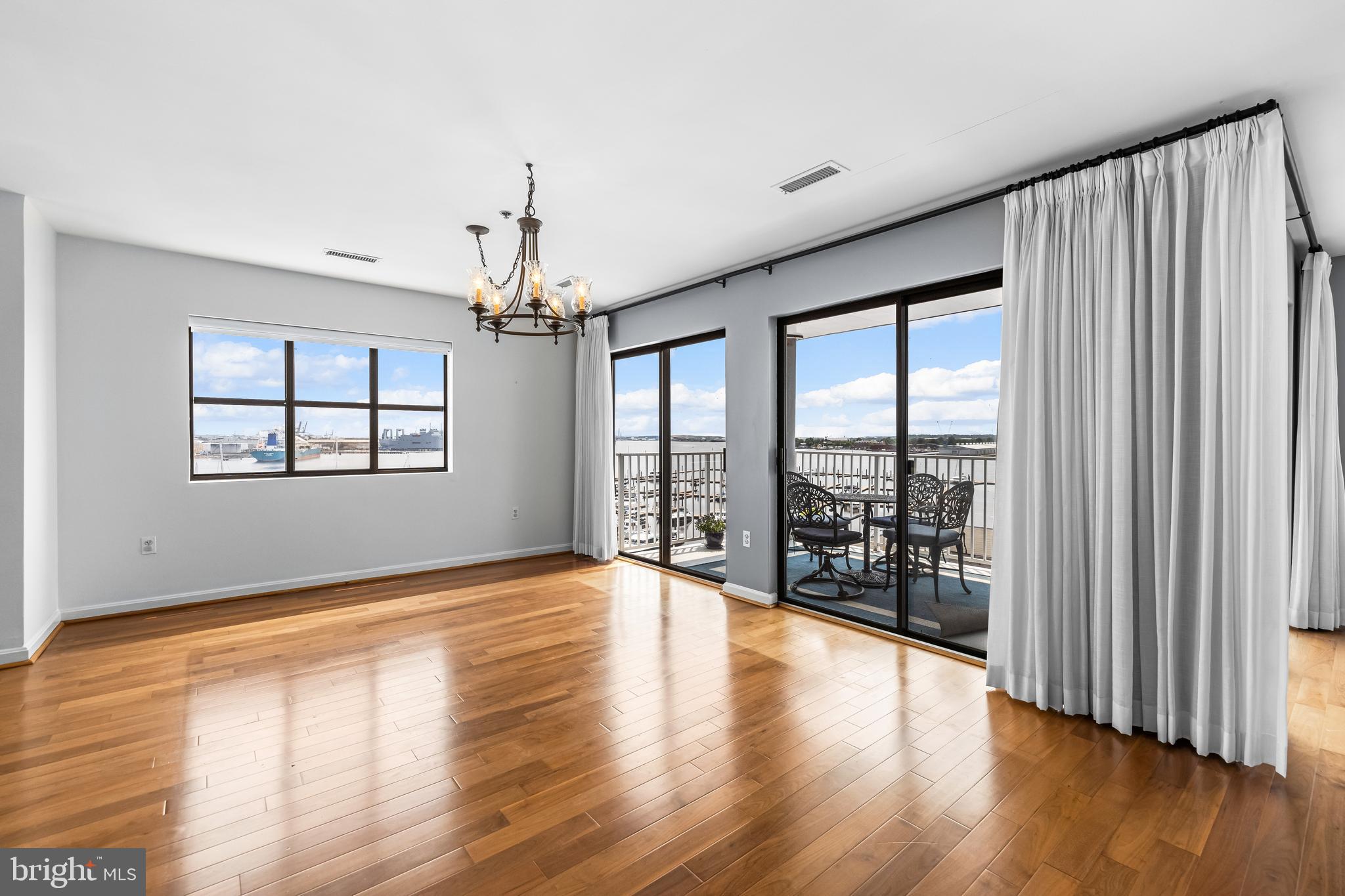 2702 Lighthouse Point East, Unit 638 Baltimore, MD 21224 - Photo 24 of 72 an empty room with wooden floor and windows