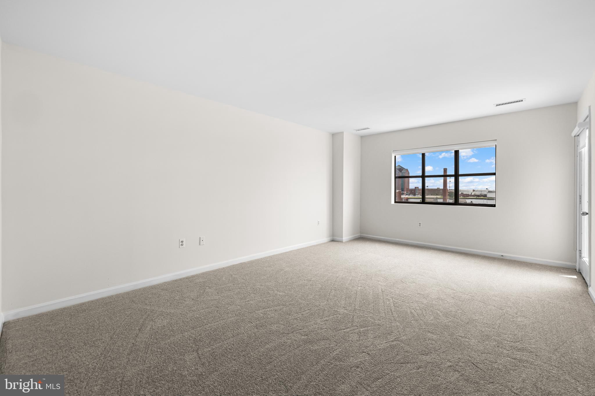 2702 Lighthouse Point East, Unit 638 Baltimore, MD 21224 - Photo 37 of 72 an empty room with windows and mirror