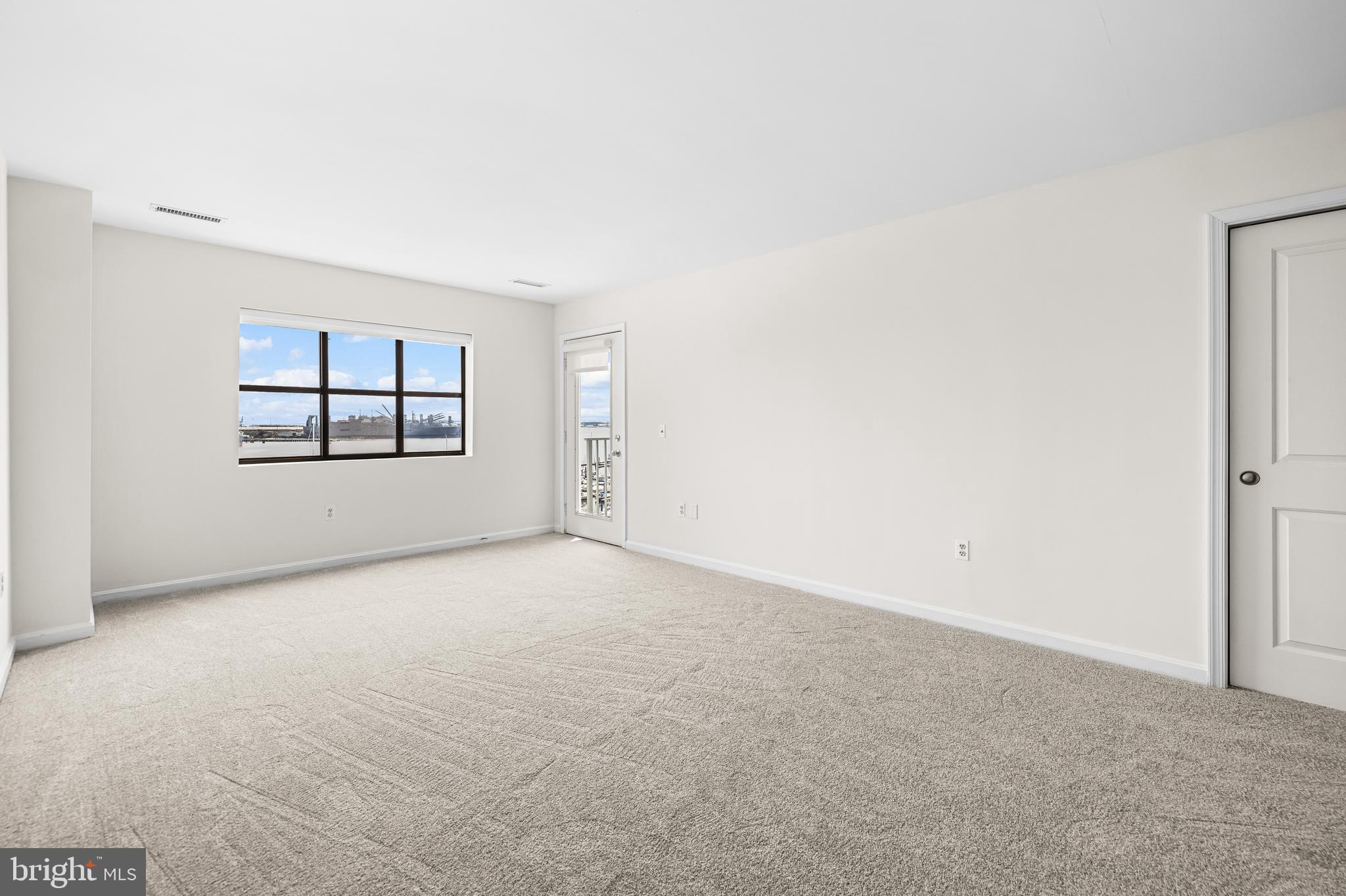 2702 Lighthouse Point East, Unit 638 Baltimore, MD 21224 - Photo 39 of 72 an empty room with windows and mirror