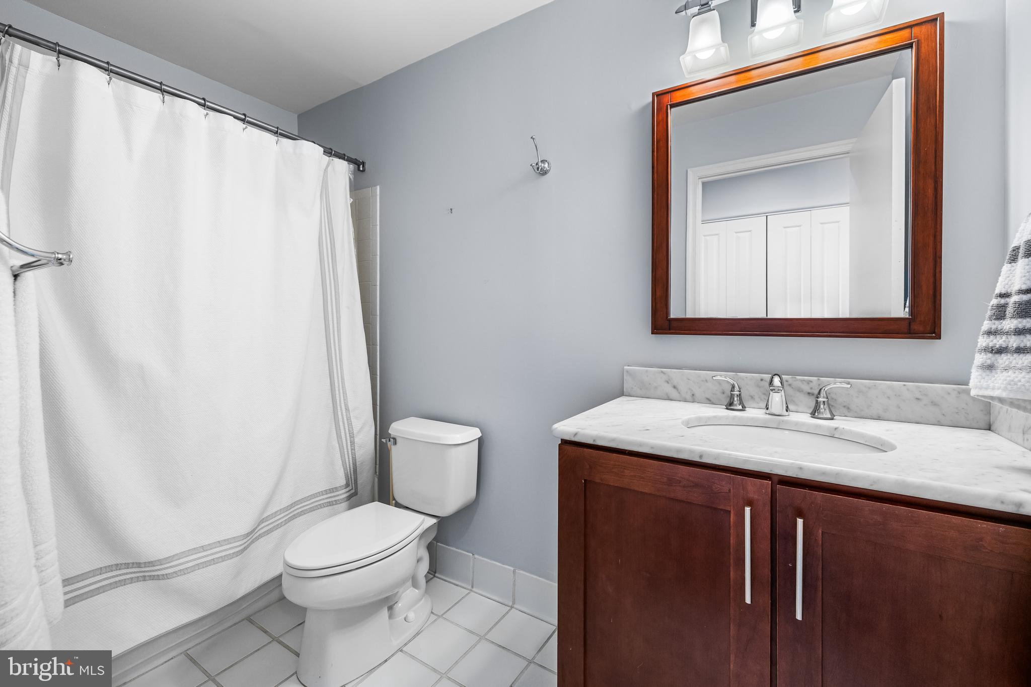2702 Lighthouse Point East, Unit 638 Baltimore, MD 21224 - Photo 40 of 72 a bathroom with a granite countertop sink toilet and mirror