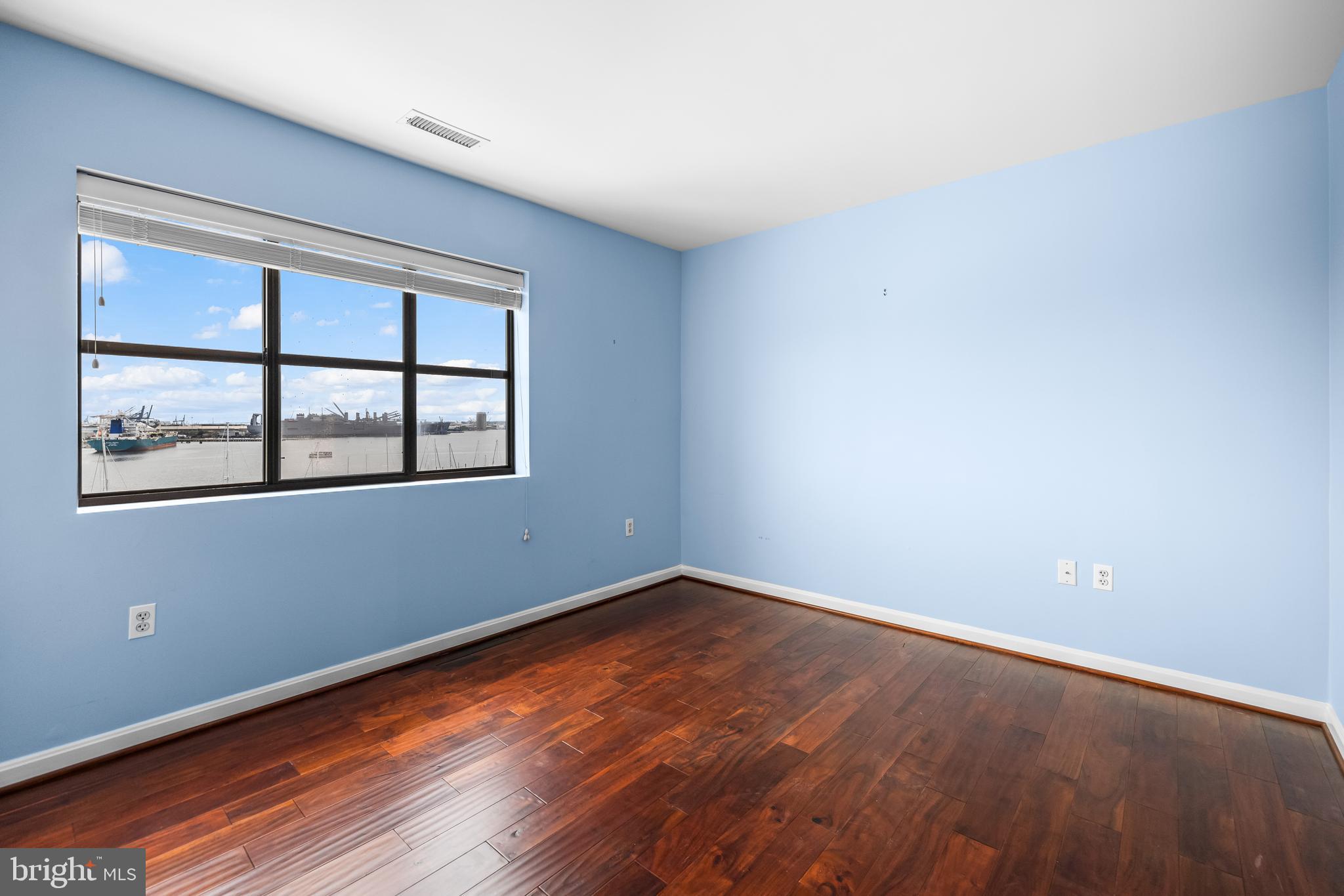 2702 Lighthouse Point East, Unit 638 Baltimore, MD 21224 - Photo 42 of 72 an empty room with wooden floor and windows