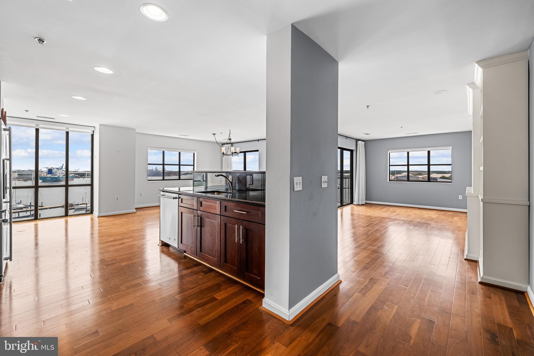 2702 Lighthouse Point East, Unit 638 Baltimore, MD 21224 - Photo 8 of 72 a kitchen with stainless steel appliances granite countertop a stove top oven and a refrigerator with wooden floor