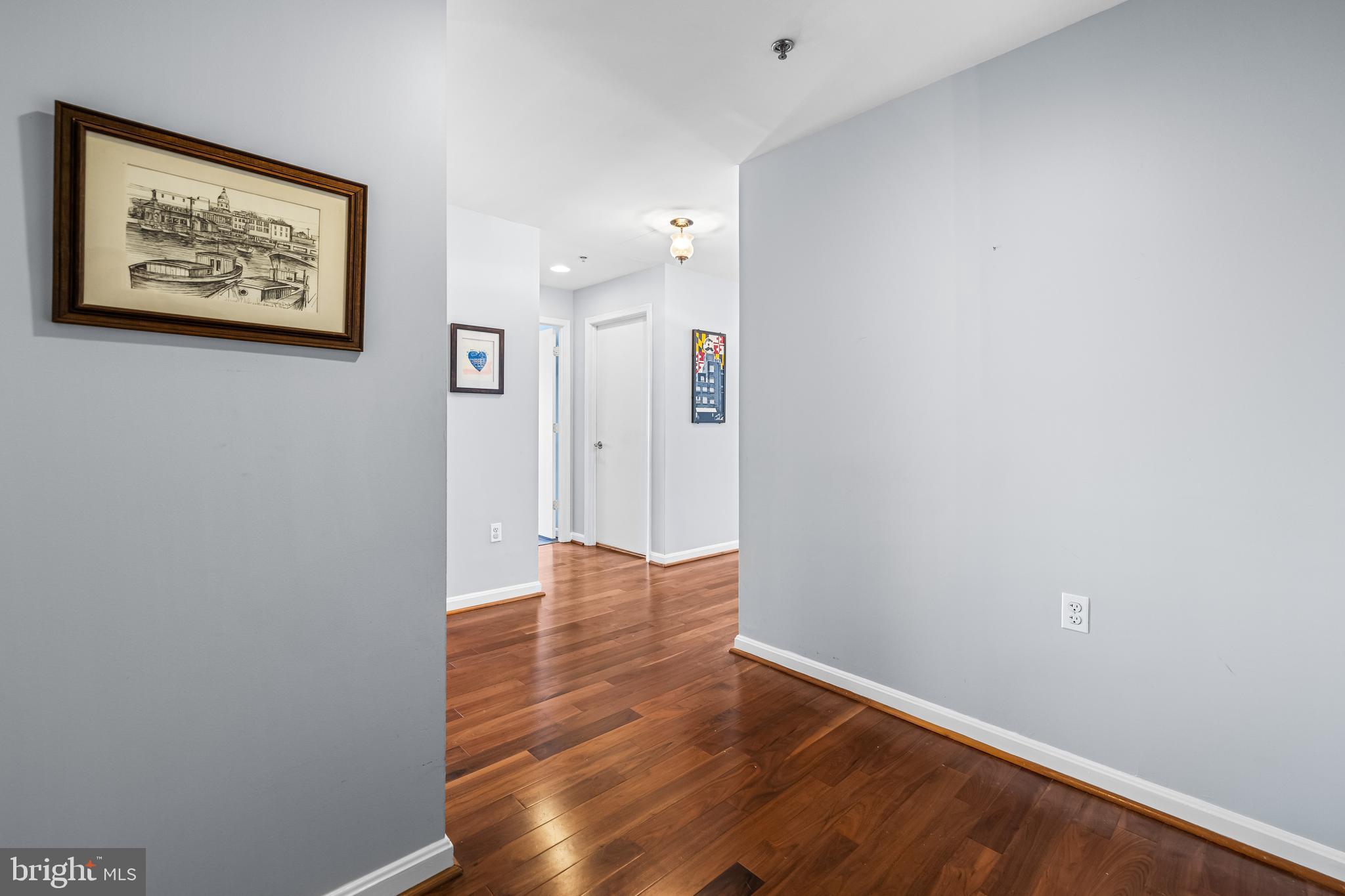 2702 Lighthouse Point East, Unit 638 Baltimore, MD 21224 - Photo 10 of 72 an empty room with wooden floor and painting on the wall