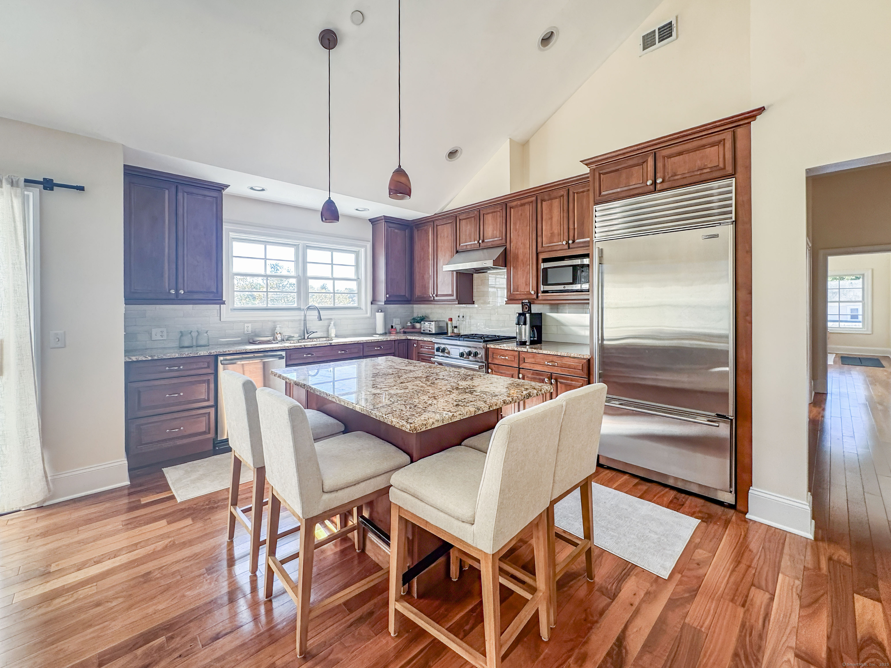 130 Post Road West, Unit PH Westport, CT 06880 - Photo 7 of 21 a kitchen with kitchen island a dining table chairs and a refrigerator