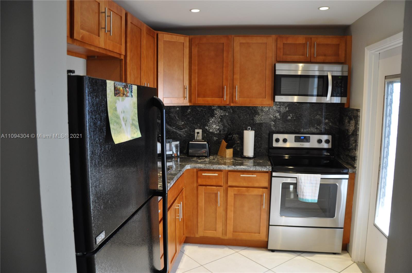a kitchen with stainless steel appliances granite countertop a stove a microwave and a refrigerator