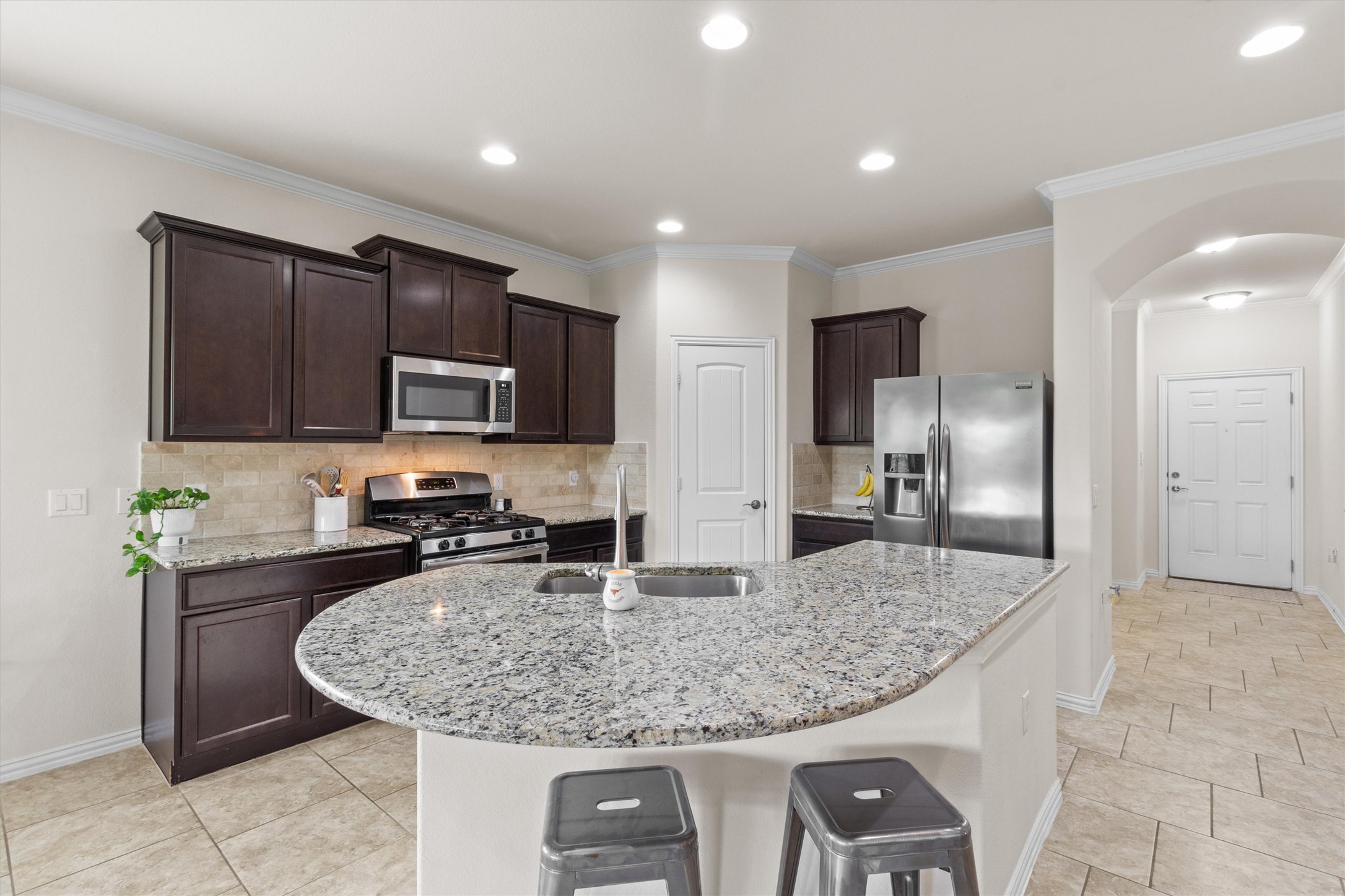 10413 Crescendo Lane Austin, TX 78747 - Photo 6 of 32 A chef-inspired kitchen features granite counters, stainless steel appliances, and elegant tile flooring.
