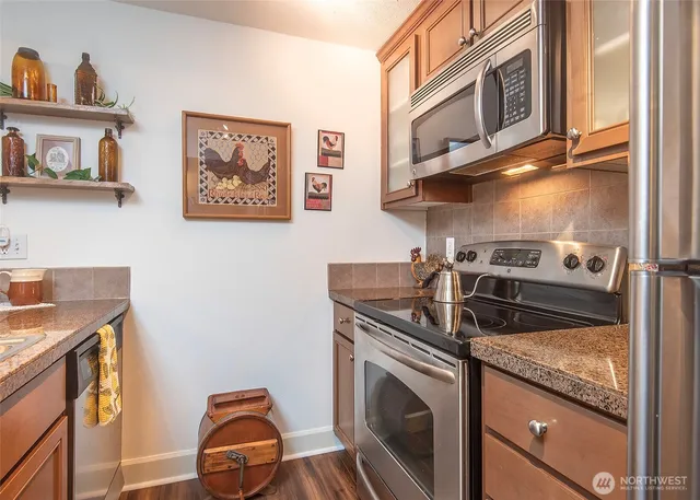 a kitchen with stainless steel appliances granite countertop a sink and a stove
