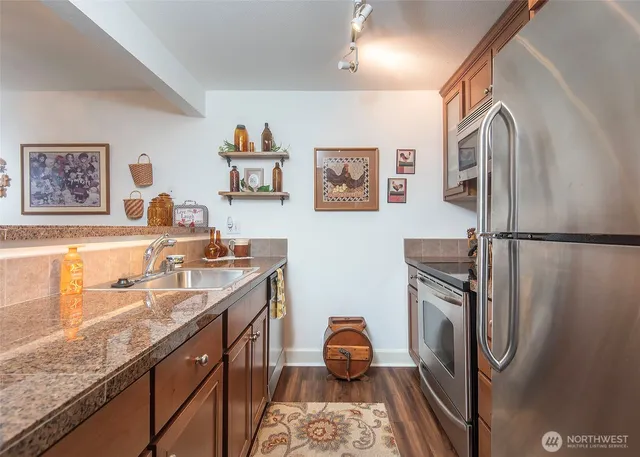 a kitchen with stainless steel appliances granite countertop a sink stove and refrigerator