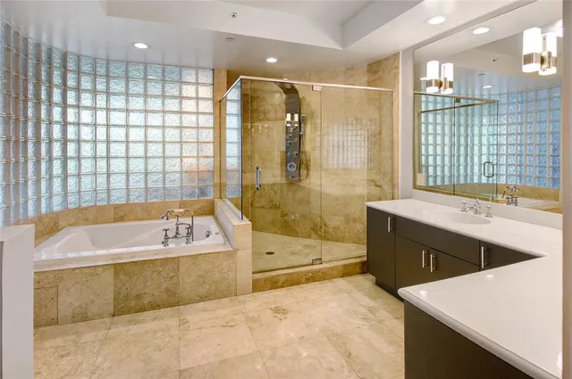 a spacious bathroom with a tub sink shower and mirror