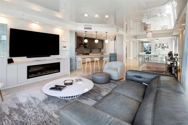 a living room with furniture a flat screen tv and kitchen view