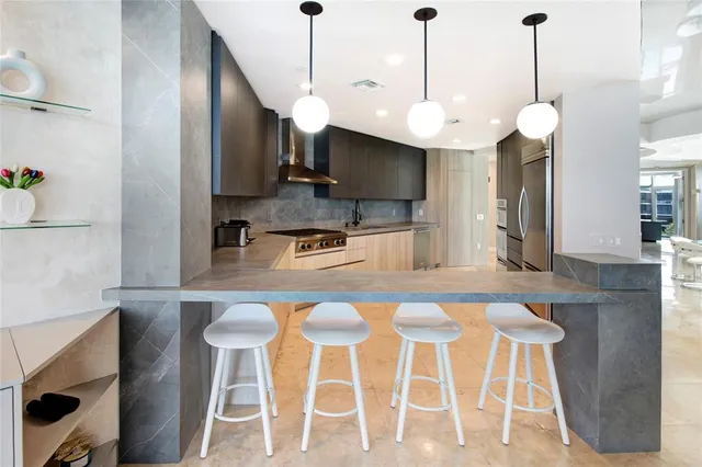 a kitchen with stainless steel appliances island dining table and chairs