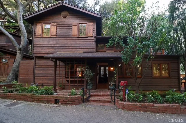 a front view of a house with a garden