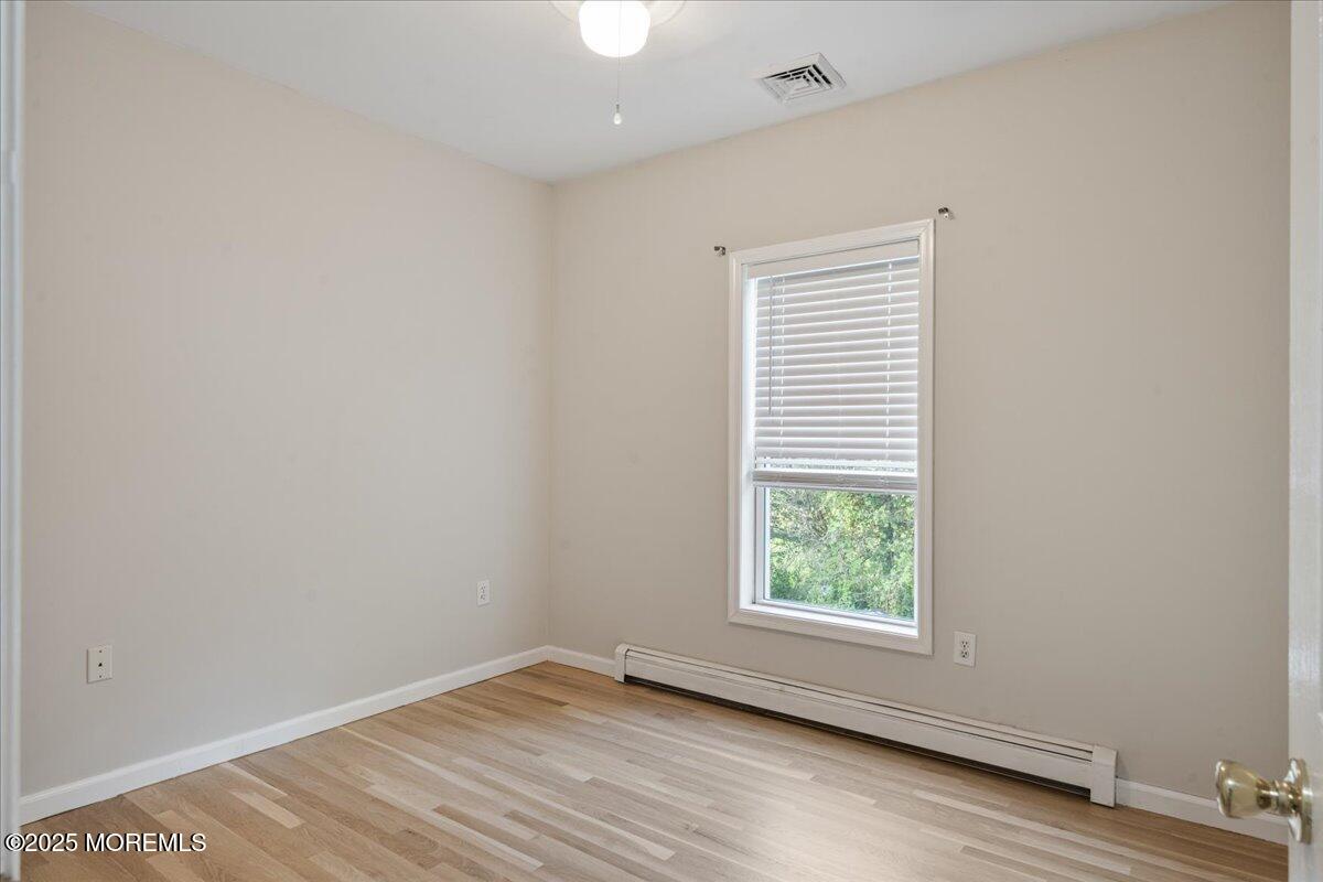 1621 Martin Road Neptune, NJ 07753 - Photo 24 of 54 an empty room with wooden floor and windows