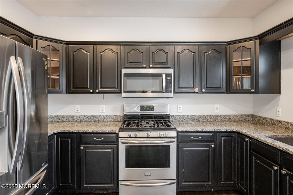 1621 Martin Road Neptune, NJ 07753 - Photo 35 of 54 a kitchen with granite countertop a stove and a microwave