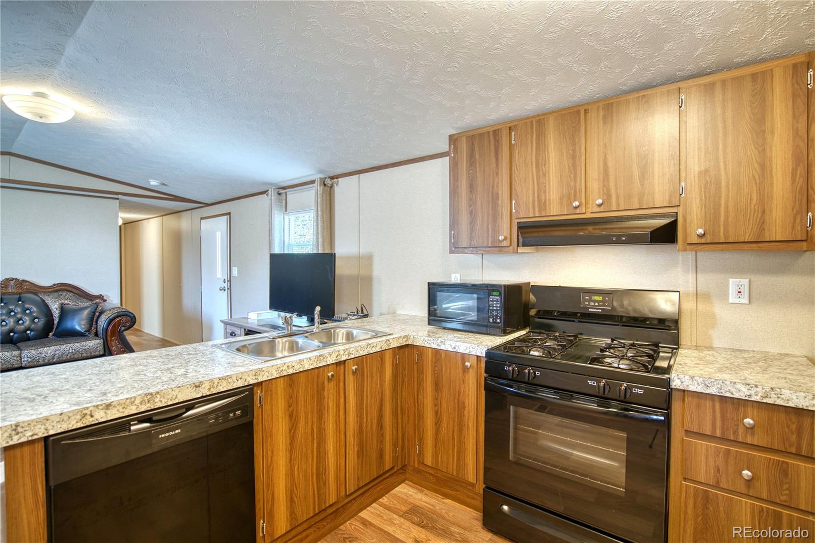 218 Grape Street Hudson, CO 80642 - Photo 2 of 17 a kitchen with stainless steel appliances granite countertop a stove a sink and a microwave