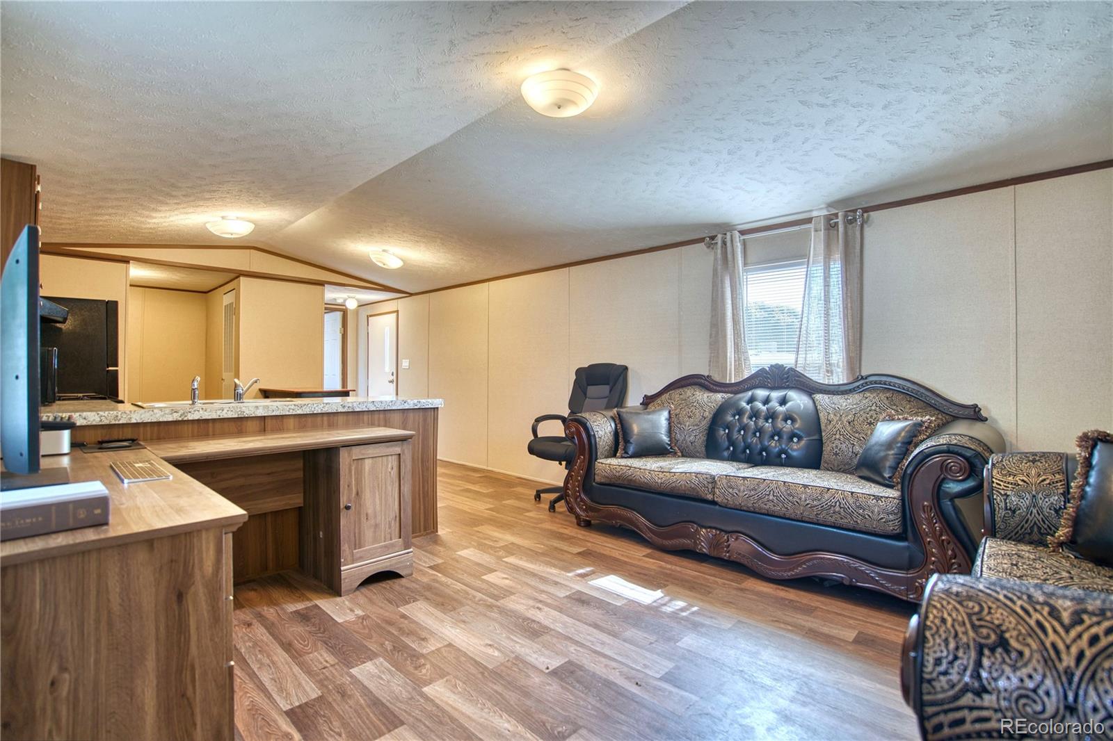 218 Grape Street Hudson, CO 80642 - Photo 5 of 17 a living room with furniture and a fireplace