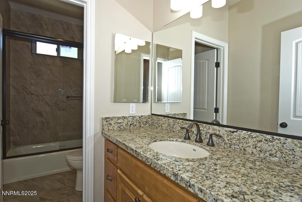 646 Anderson Street Carson City, NV 89701 - Photo 18 of 25 a bathroom with a granite countertop sink and a mirror