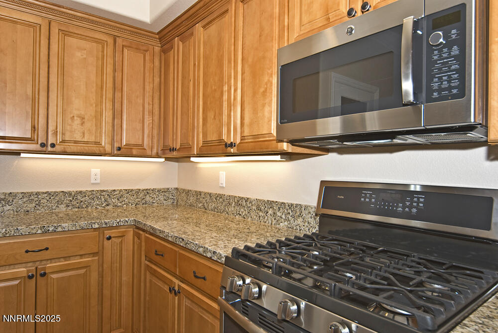 646 Anderson Street Carson City, NV 89701 - Photo 5 of 25 a kitchen with granite countertop a stove and a microwave
