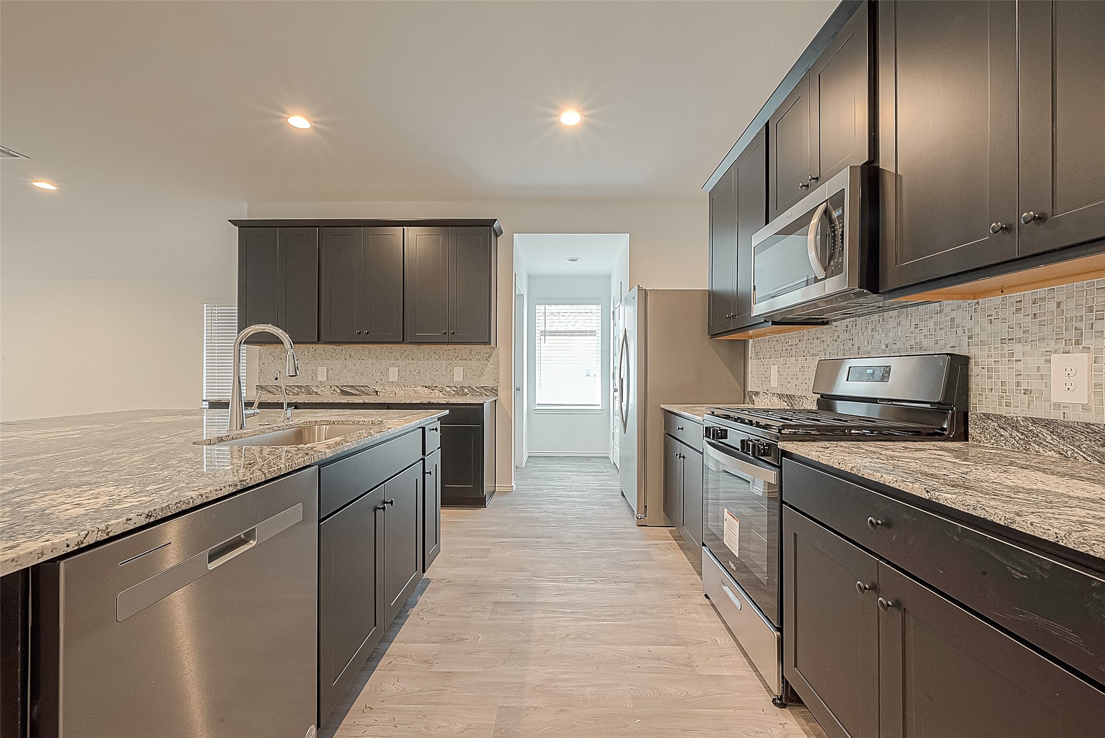 2731 Willow Gulch Way Rosenberg, TX 77469 - Photo 15 of 50 a large kitchen with stainless steel appliances granite countertop a sink and a stove